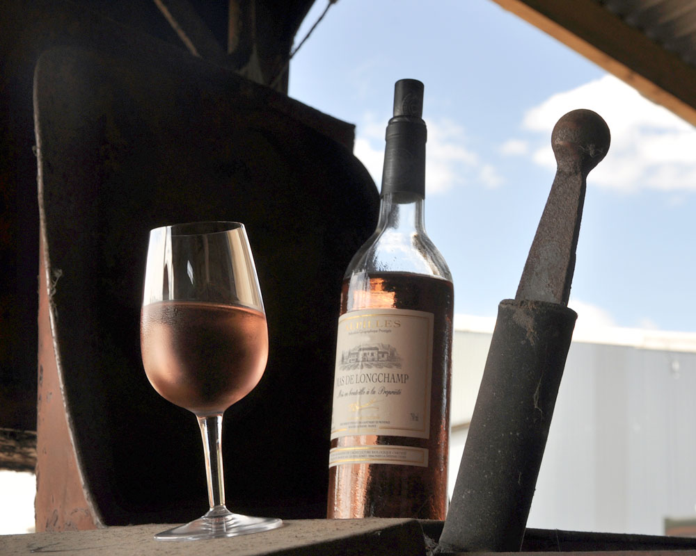 Chilled rosé wine in a glass next to bottle of rosé wine